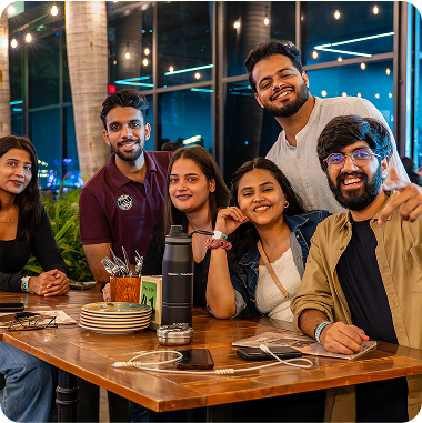 Several young individuals seated at a table, sharing ideas and enjoying each other's company