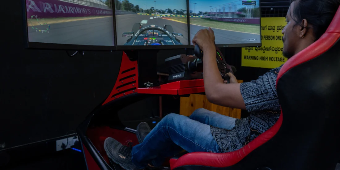 A man intensely focused on a racing simulator, gripping the steering wheel while playing a racing video game