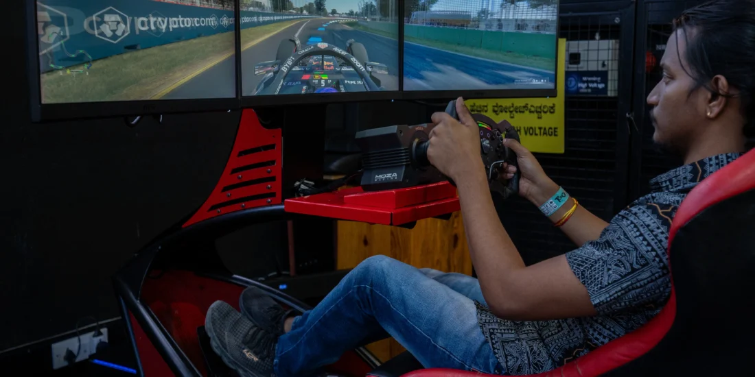 A man intensely focused on a racing simulator, gripping the steering wheel while playing a racing video game