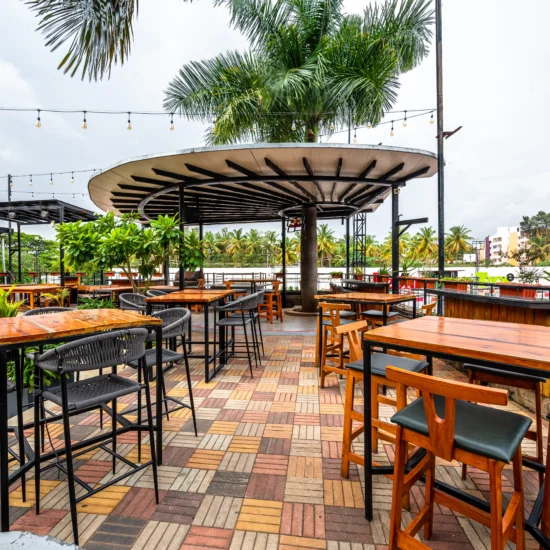 Outdoor patio at the hotel bar featuring tables, chairs, and greenery, ideal for relaxing and socializing