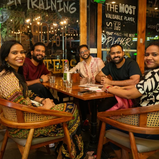 Several people gathered at a restaurant table, sharing food and conversation in a lively dining atmosphere