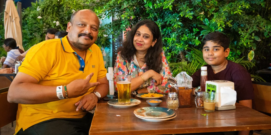 A family gathered around a table enjoying drinks and food together in a warm, inviting setting