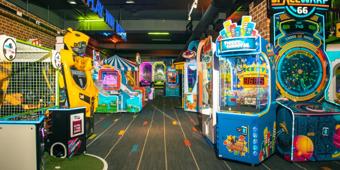 A lively game room showcasing arcade machines and an assortment of toys, perfect for fun and recreation