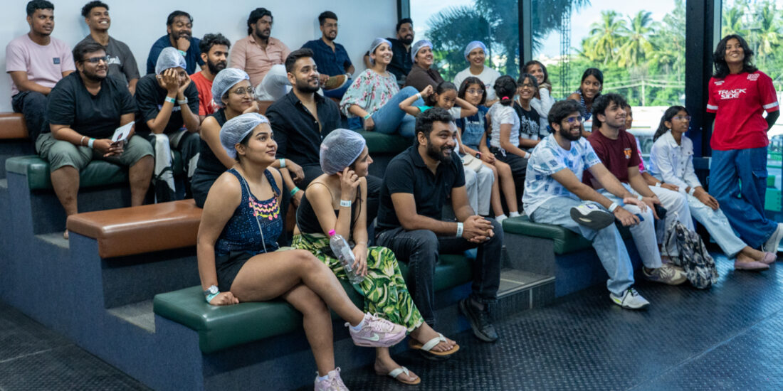 A group of people seated on benches, facing a large window that lets in natural light Learning Guide to ride Go Karting