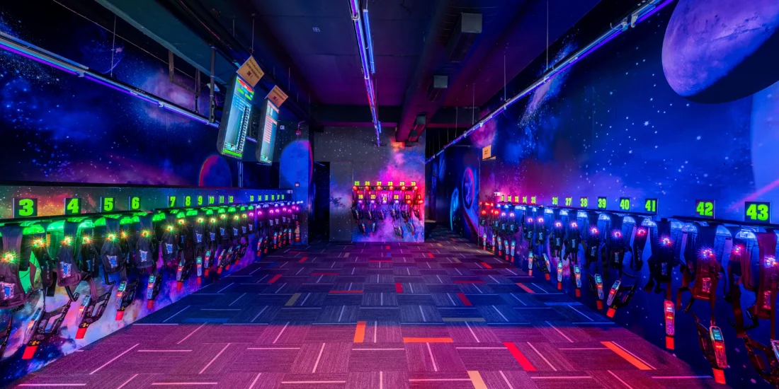 A vibrant bowling alley featuring neon lights and colorful walls, creating a lively and energetic atmosphere