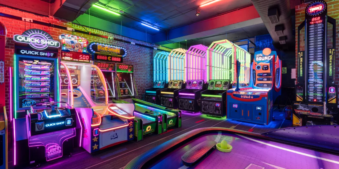 A lively game room filled with arcade machines and a pool table, inviting fun and social interaction