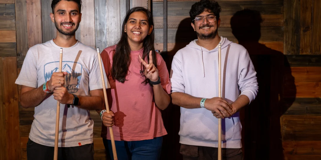 Three people ready to play 8pool standing with stick