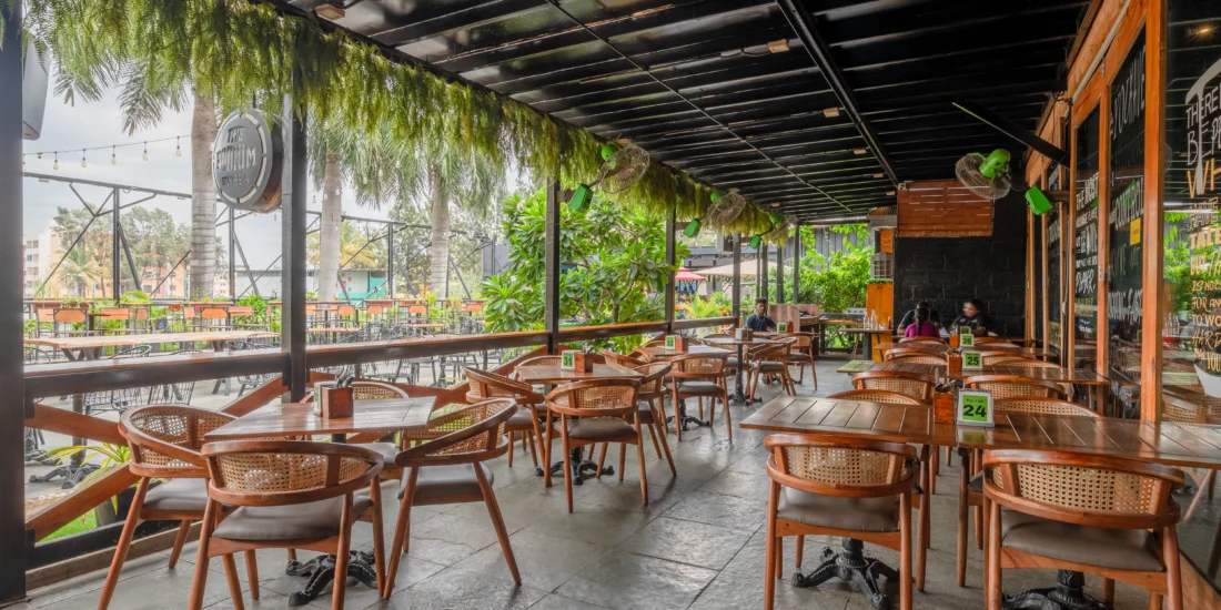 A restaurant patio featuring several tables and chairs arranged for outdoor dining