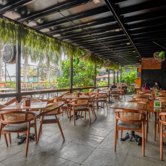 A restaurant patio featuring several tables and chairs arranged for outdoor dining