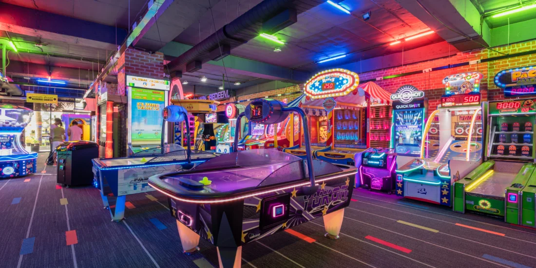 A vibrant game room filled with various arcade games and machines, inviting players to enjoy classic gaming experiences