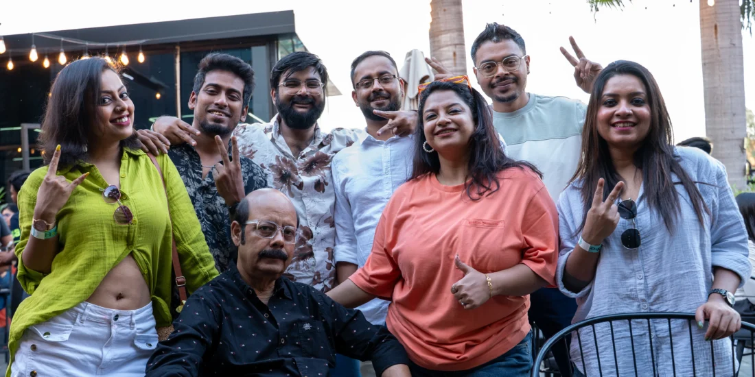 A group of people smiling and posing together in front of a table, capturing a moment of camaraderie