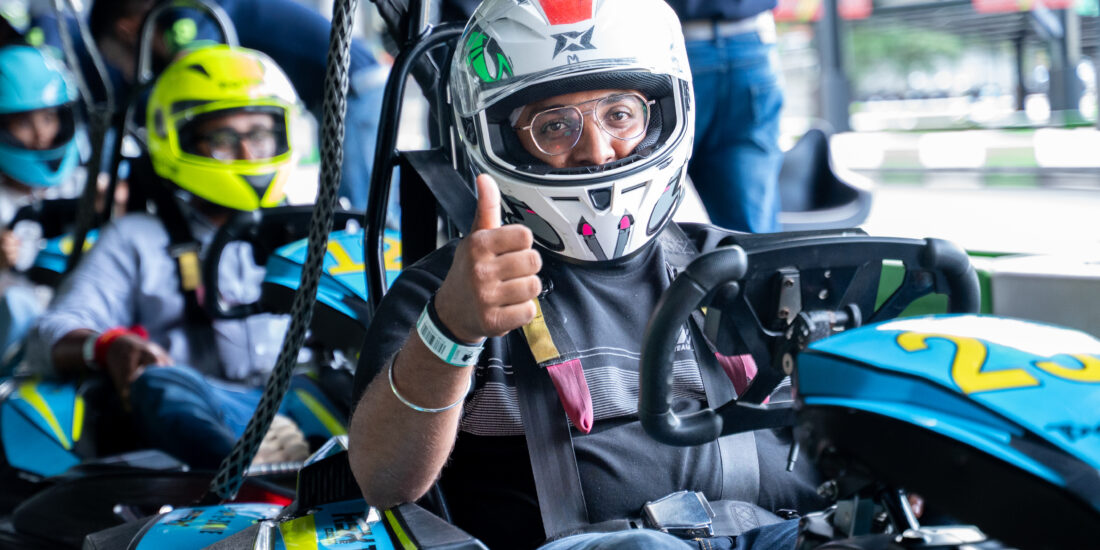 Man sitting in Go karting with an helmet showing tumbsup