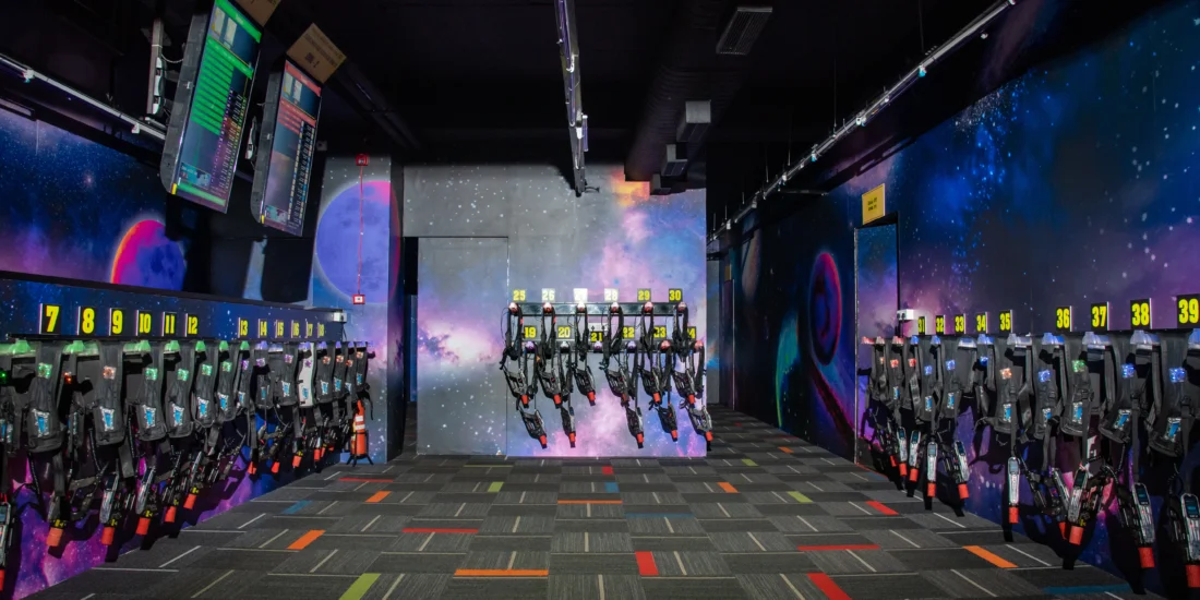 A room filled with colorful skateboards and a space-themed mural on the wall, creating a vibrant atmosphere