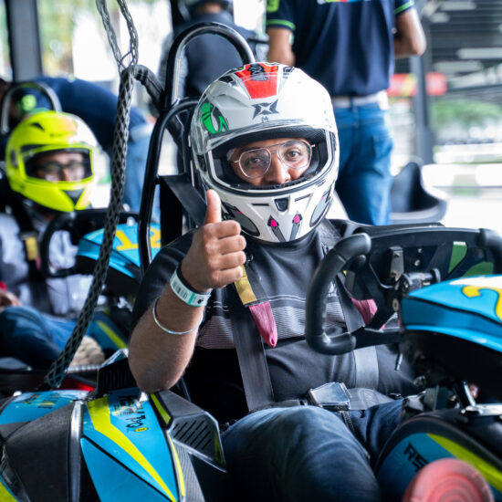 Man sitting in Go karting with an helmet showing tumbsup