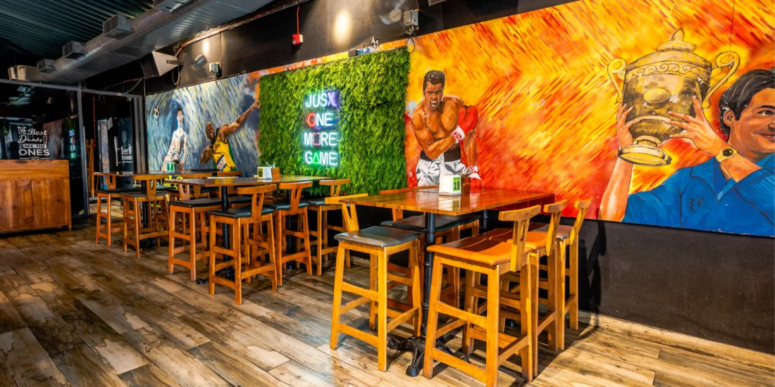 Interior of a restaurant showcasing a vibrant mural and wooden tables arranged for guests