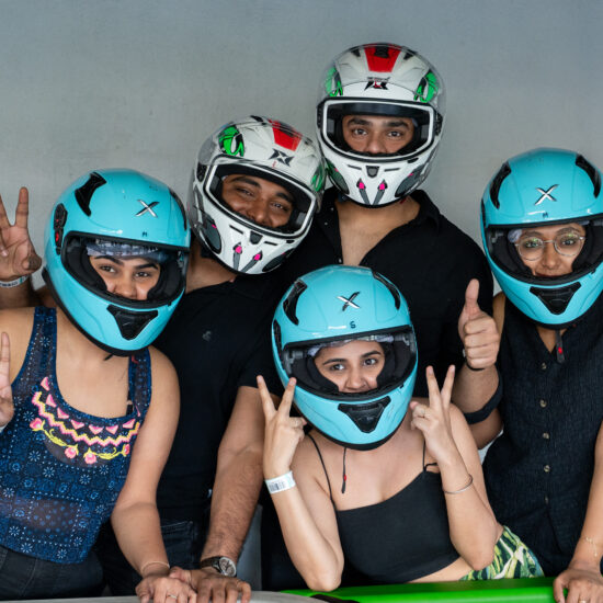 Several individuals in helmets stand together, smiling for a group photo, highlighting their teamwork and safety precautions ready to ride for Go Karting